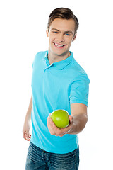 Image showing Good looking healthy guy offering a green apple