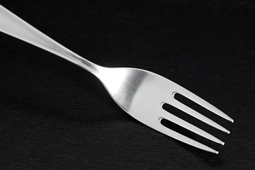 Image showing Shiny silver fork on dark wooden background