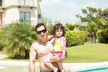 Image showing Father and daughter beside the swimming pool 