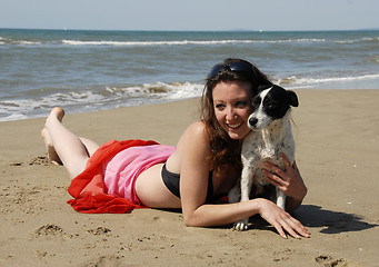 Image showing happy woman on the beach with her dog