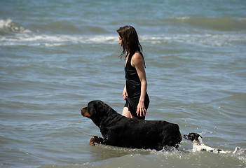 Image showing woman and dogs on the sea