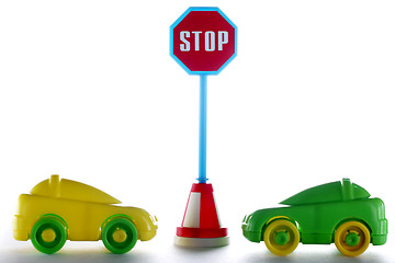 Image showing A couple cars behind stop road sign