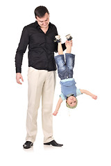 Image showing Man holds little boy upside down