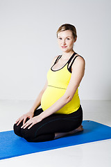 Image showing Pregnant woman kneeling on mat