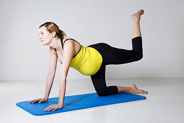 Image showing Pregnant woman exercising on mat