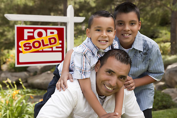 Image showing Hispanic Father and Sons in Front of Sold Real Estate Sign
