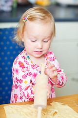 Image showing Toddler girl helping at kitchen