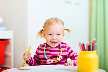 Image showing Toddler girl drawing with pencils