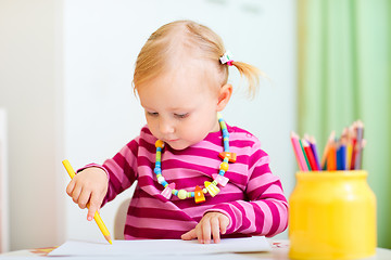 Image showing Toddler girl coloring with pencils