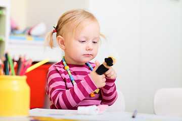 Image showing Toddler girl playing with finger puppets