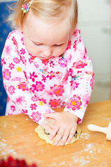 Image showing Adorable toddler girl helping at kitchen