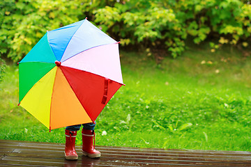 Image showing Little girl hiding behind umbrella