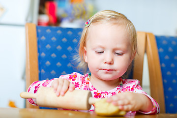 Image showing Toddler girl helping at kitchen