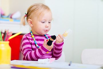 Image showing Toddler girl playing with finger toys