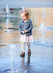 Image showing Little girl playing in street fountain