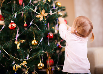 Image showing Little girl decorating Christmas tree