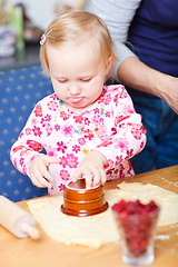 Image showing Adorable toddler girl helping at kitchen