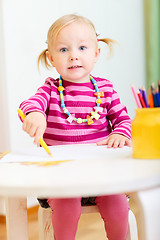 Image showing Toddler girl drawing with pencils