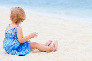Image showing Toddler girl sitting on white sand beach