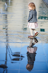 Image showing Little girl playing in street fountain