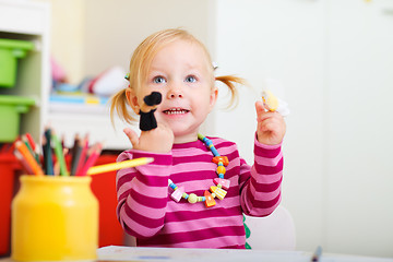 Image showing Toddler girl playing with finger puppets