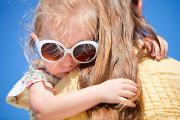 Image showing Close up of little girl hugging mom