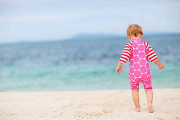 Image showing Toddler girl sitting on white sand beach