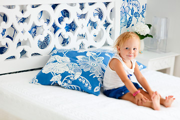 Image showing Toddler girl sitting on bed