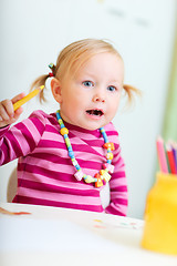 Image showing Toddler girl drawing with pencils