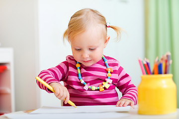 Image showing Toddler girl drawing with pencils