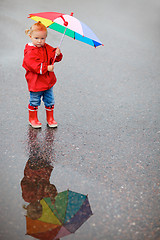 Image showing Toddler girl with colorful umbrella on rainy day