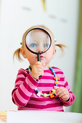 Image showing Toddler girl playing with magnifier