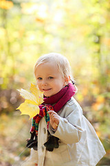 Image showing Toddler girl holding yellow leaf