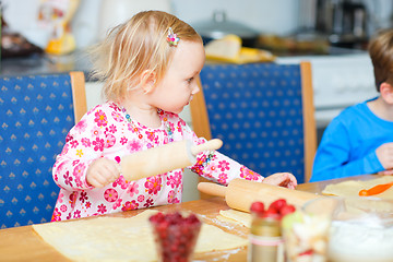 Image showing Toddler girl helping at kitchen