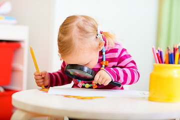 Image showing Toddler girl looking through magnifier