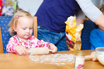 Image showing Toddler girl helping at kitchen