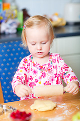 Image showing Little girl helping at kitchen