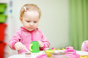 Image showing Toddler girl playing with wooden toys