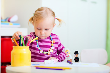 Image showing Toddler girl coloring with pencils