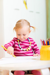 Image showing Toddler girl drawing with pencils