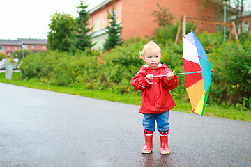 Image showing Toddler girl with umbrella outside on rainy day