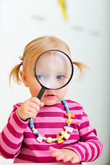 Image showing Toddler girl looking through magnifier