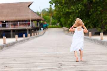 Image showing Little girl running on jetty