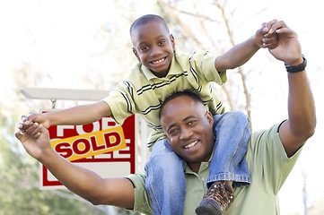 Image showing Father and Son In Front of Real Estate Sign