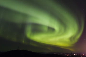 Image showing Aurora swirls over town