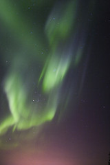 Image showing Aurora borealis over town lights glow