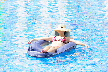 Image showing woman resting and tanning in the pool 