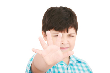 Image showing Child looking at camera. Stop signal with his hand.  Boy trying 