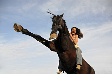 Image showing rearing stallion and laughing girl