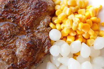 Image showing grilled pork steak with corn and small onions